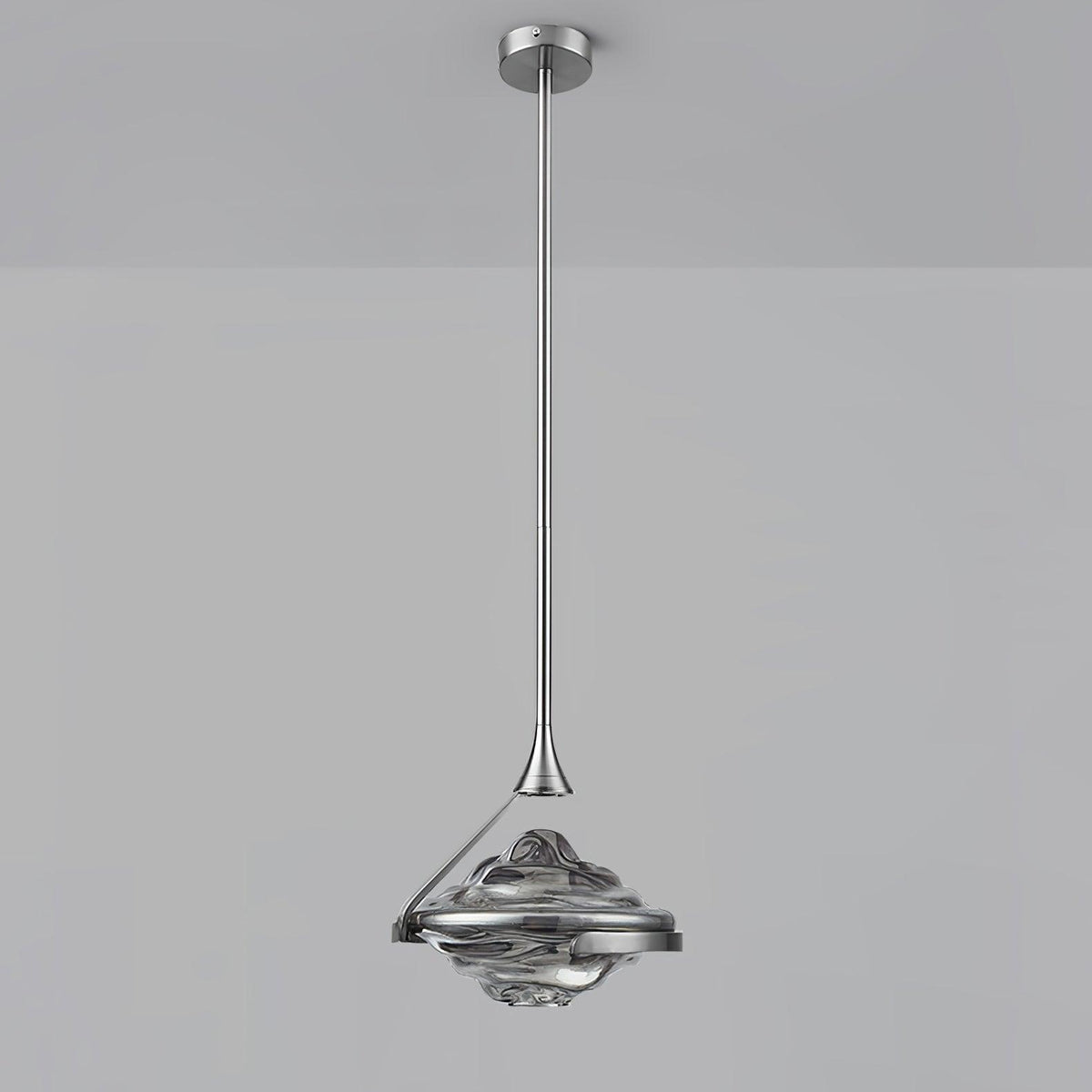A faceted smoke grey glass pendant on a chrome rod and ceiling plate hangs against a grey backdrop, from Clérachic.