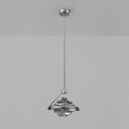 A faceted smoke grey glass pendant on a chrome rod and ceiling plate hangs against a pale grey wall, from Clérachic.