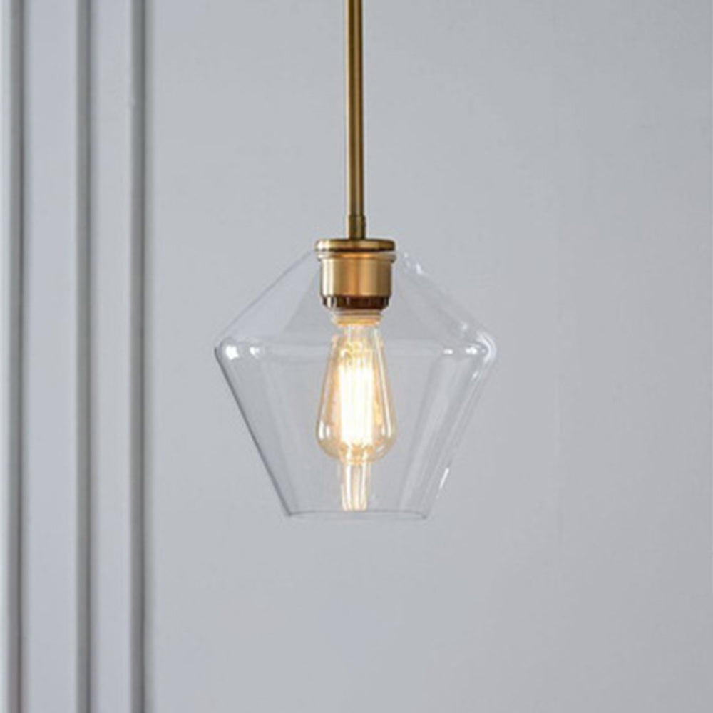 Clérachic faceted glass pendant light in clear glass, the diamond-faceted taper glowing over a pale panelled corner.