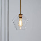 Clérachic faceted glass pendant light in clear glass, the diamond-faceted taper glowing over a pale panelled corner.