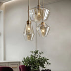 Clérachic faceted glass pendant lights grouped over a kitchen corner, three amber shades above a potted eucalyptus.