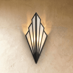 Clérachic Art Deco wall lamp in black, a fan of linen panels in a slim iron frame, lit warm against a textured wall.