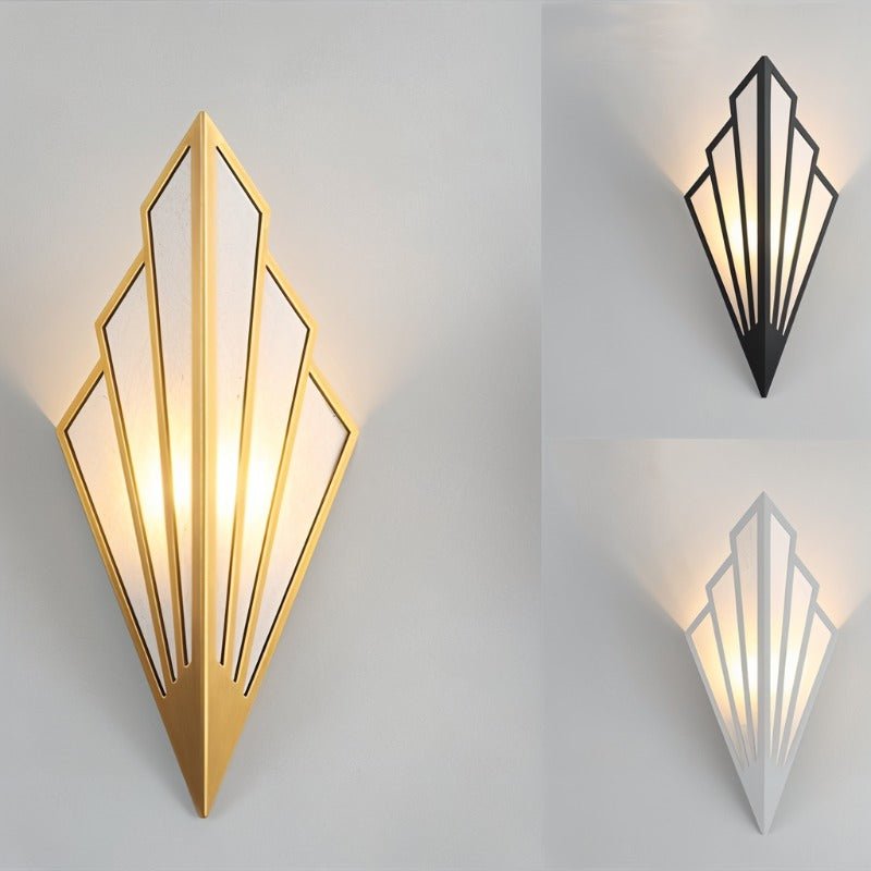 Clérachic Art Deco wall lamp shown in gold, with smaller black and white versions at the right, all lit warm on grey.