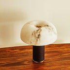 Seen from above, the domed shade of this Clérachic table lamp shows its veining and a central opening, with a wood table below.