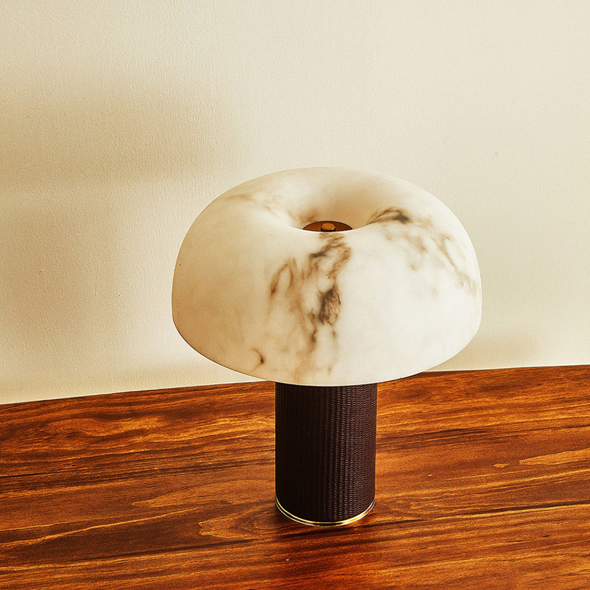 Seen from above, the domed shade of this Clérachic table lamp shows its veining and a central opening, with a wood table below.