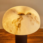Close view of the glowing, veined domed shade on this Clérachic lamp, with the top of its dark woven base at the bottom.