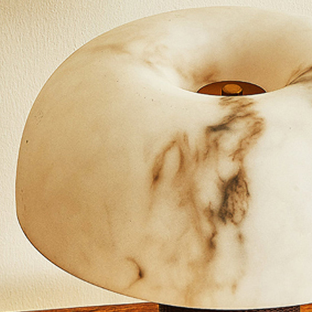 Close view of the veined, marbled shade of this Clérachic lamp, with a small brass cap at the centre.
