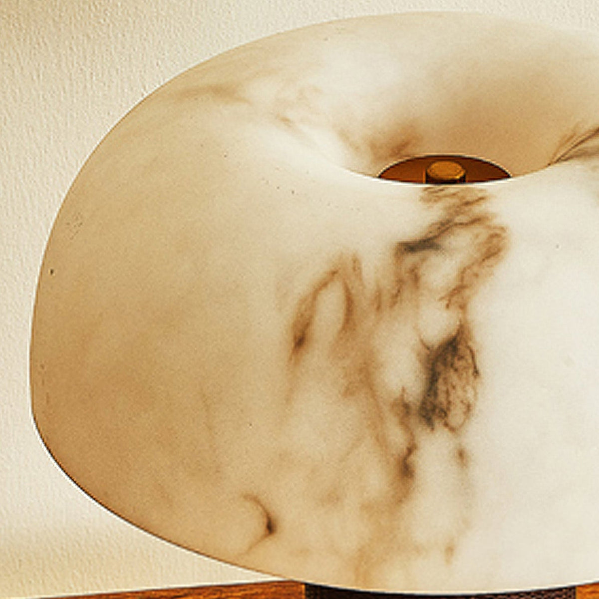 Close view of the veined, marbled shade of this Clérachic lamp, with a small brass cap at the centre.