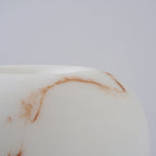 Close view of the rounded edge of the shade on this Clérachic lamp, with a fine rust-coloured vein across the white.