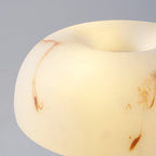 Close view of the lit, rounded shade of this Clérachic lamp, with swirls of rust-coloured veining in the white.