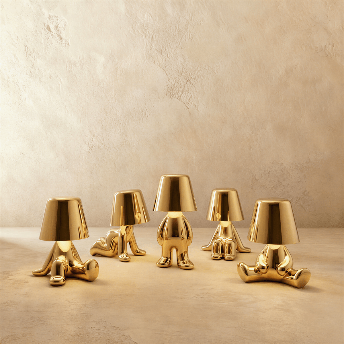 Clérachic set of five gold figurine table lamps in reclining, seated and standing poses, each glowing warm white.
