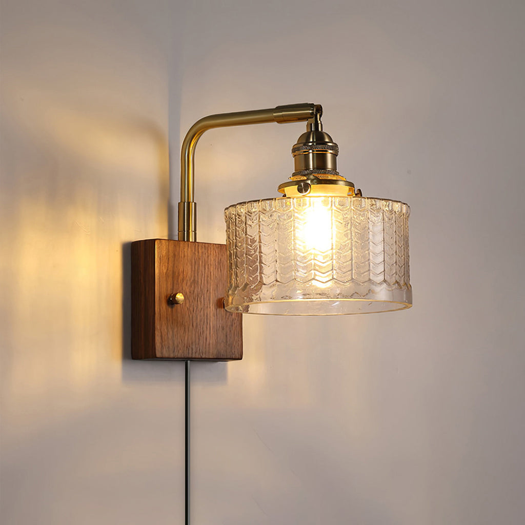 The clear glass version of the Clérachic fish-scale wall sconce, chevron relief warming to amber-gold above a plug-in cord.