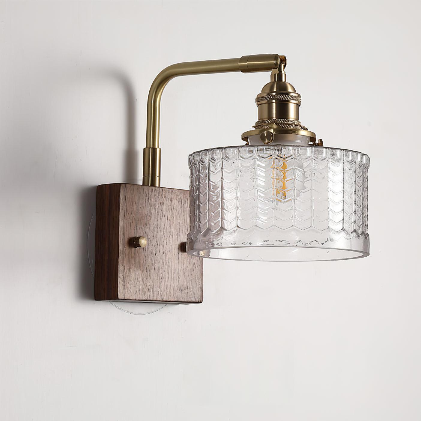 Clérachic fish-scale glass wall sconce in clear glass, the chevron columns lit from within against a plain white wall.