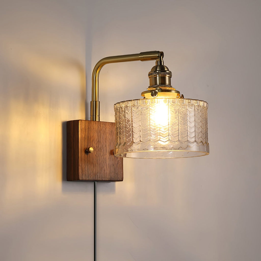 Clérachic fish-scale glass wall sconce in clear glass, the open foot of the drum casting light straight down the wall.