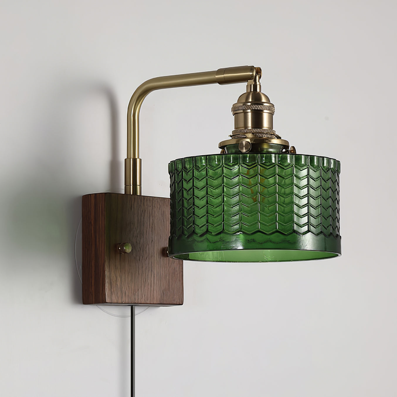 Side view of the Clérachic fish-scale glass wall sconce, showing the brass arm, knurled holder and open-bottomed green drum.