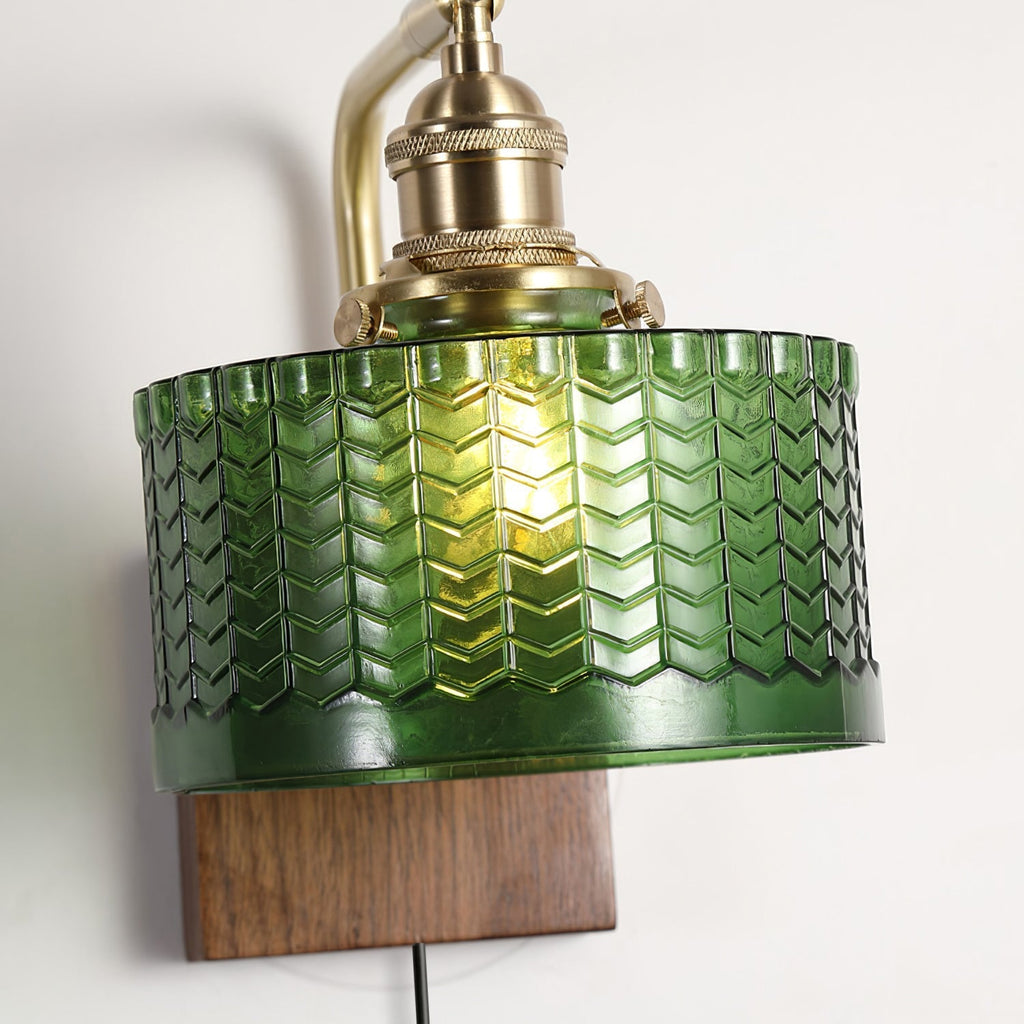 Close-up of the Clérachic fish-scale glass wall sconce shade, chevron relief and scalloped saw-tooth border under a brass holder.