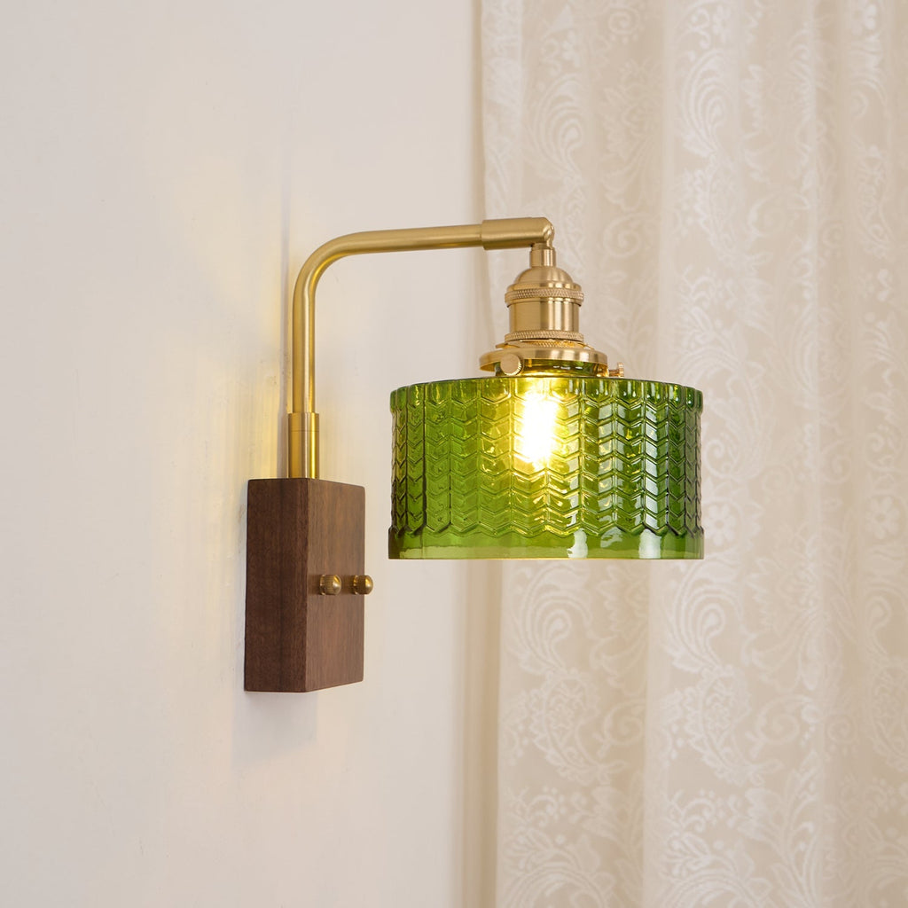 Clérachic fish-scale glass wall sconce beside a lace curtain, brass thumbscrews visible on the solid walnut wall block.