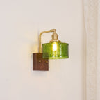 Clérachic fish-scale glass wall sconce set against a cream wall, scaled for a bedside table rather than for a statement.