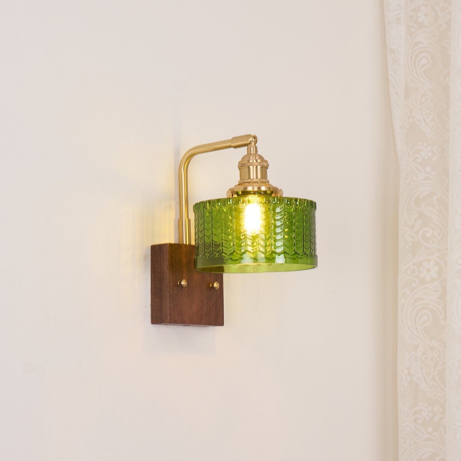 Clérachic fish-scale glass wall sconce set against a cream wall, scaled for a bedside table rather than for a statement.
