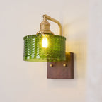 Clérachic fish-scale glass wall sconce mounted with the shade swung left, brass thumbscrews set into the walnut wall block.