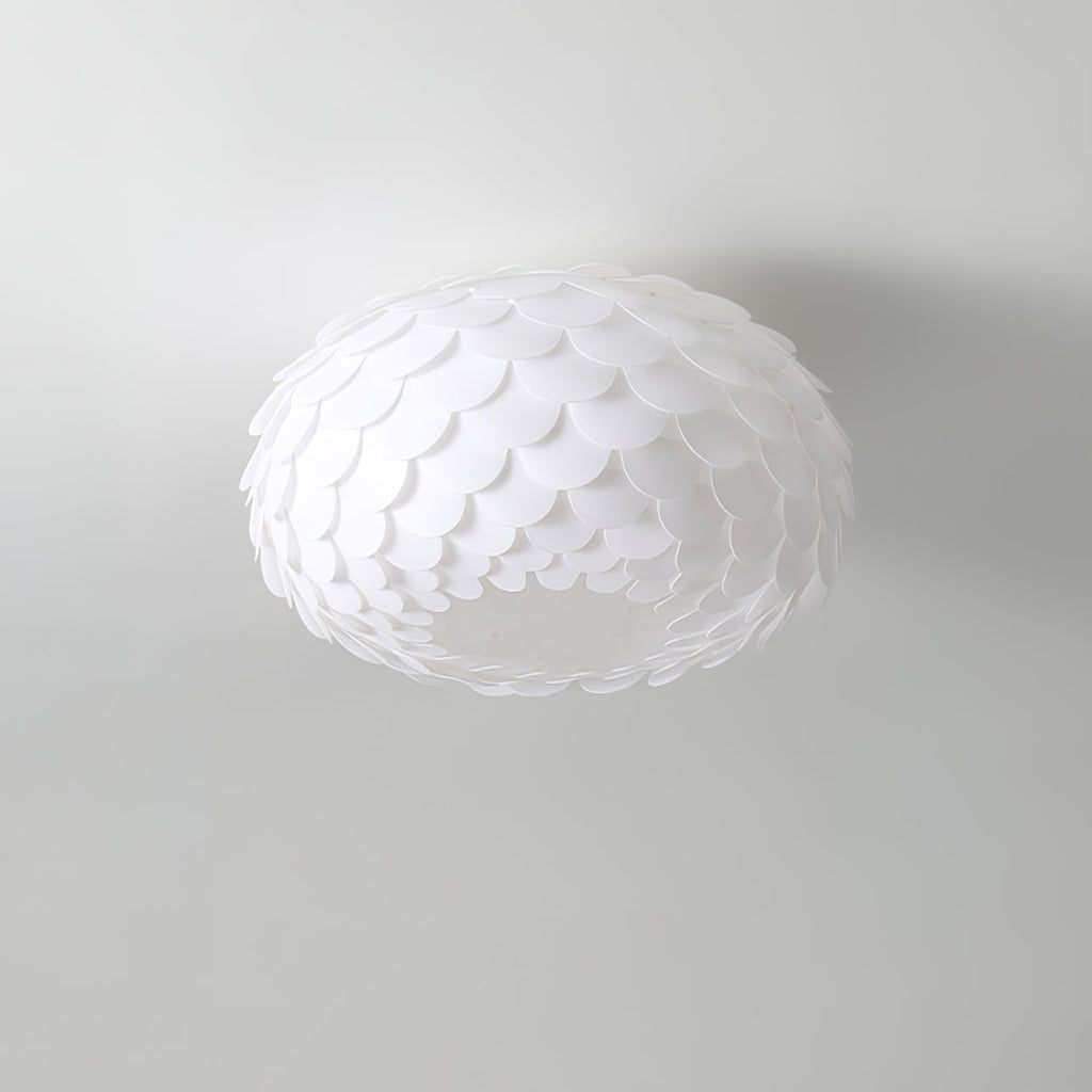 Unlit Clérachic ceiling light with layered white scales, seen from below against a pale grey ceiling.