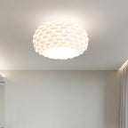This Clérachic ceiling light lit above a plain grey wall with a soft shadow line along the ceiling edge.