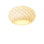 Warm-lit Clérachic ceiling light with petal-like scales and a bright underside, on a white background.