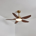 A Clérachic ceiling fan in a warm-lit view from below, its five walnut-grain blades spread beside a ceiling corner.
