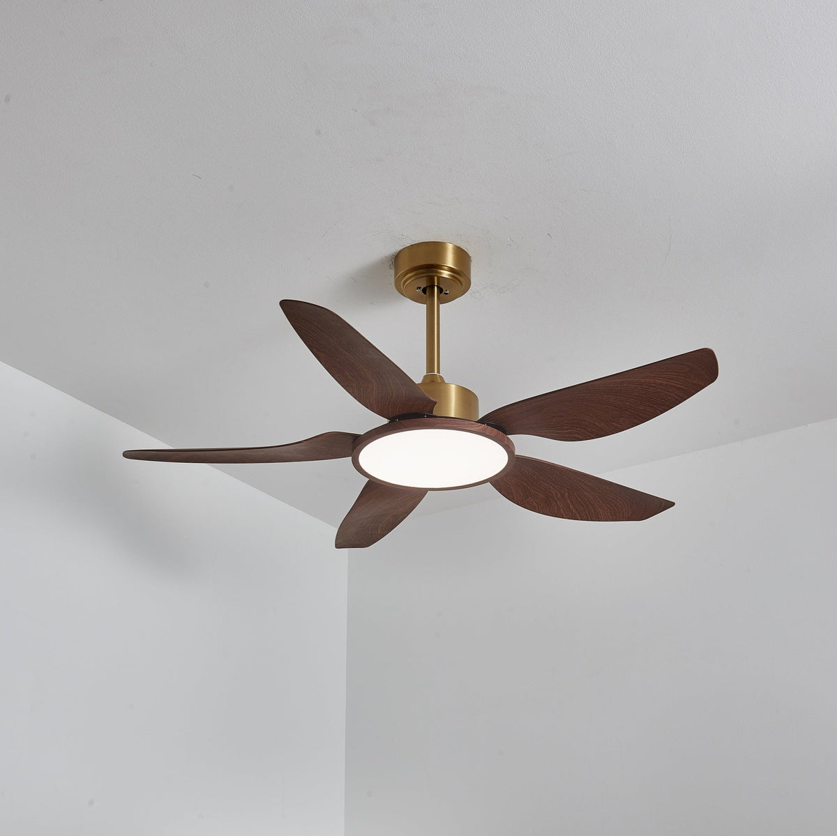 The Clérachic ceiling fan with its LED disc lit a soft neutral white, seen from below at an angle.
