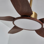Close view of the unlit light disc and walnut-grain blade roots on this Clérachic ceiling fan, with the gold down-rod above.