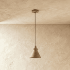 Clérachic pendant in pale yellow travertine with a flared cone shade and wooden top, hung from a round ceiling canopy
