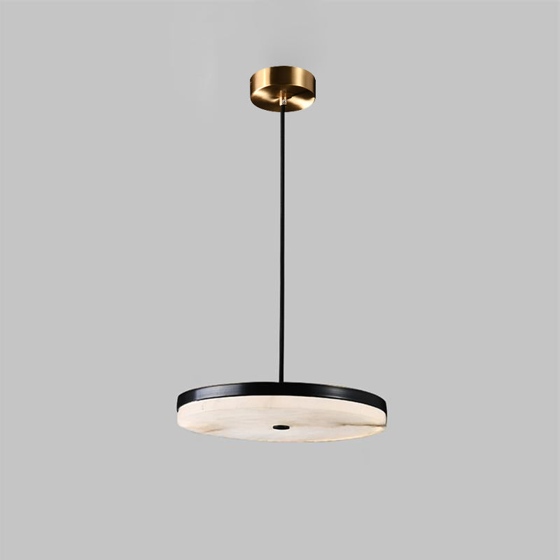 Clérachic Flat Disc Pendant Light on a studio grey backdrop, black metal rim over pale alabaster with a brass ceiling canopy.