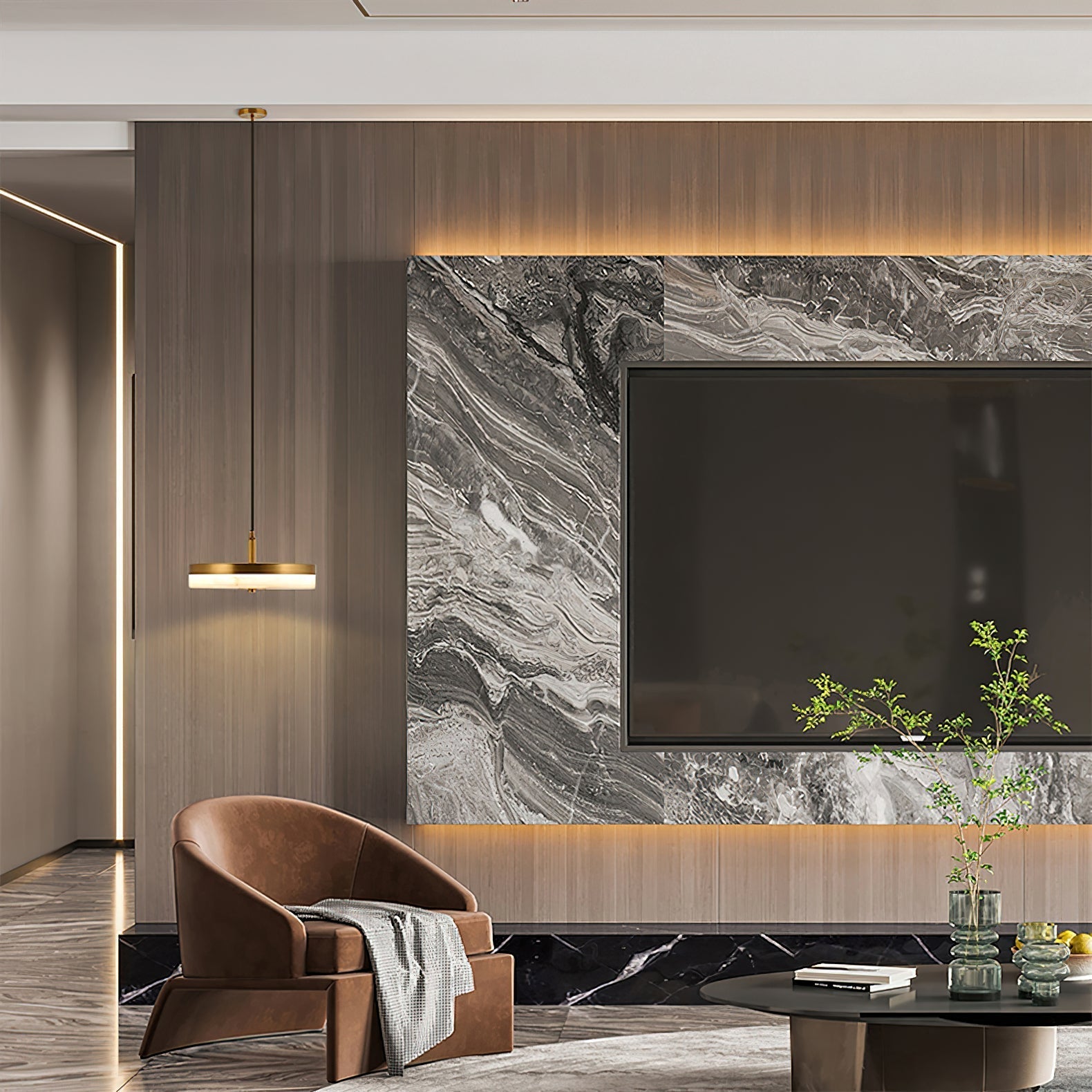 A brass Clérachic Flat Disc Pendant Light lit beside a marble media wall, hanging low over a tan leather armchair in a living room.