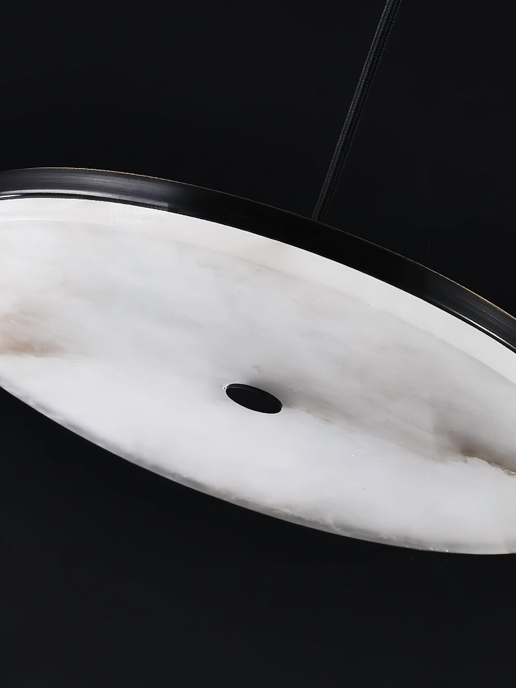 Close-up of the Clérachic Flat Disc Pendant Light from below, showing the veined alabaster underside and its small central vent.