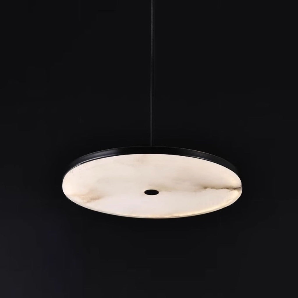 Clérachic Flat Disc Pendant Light seen from below against black, the full round alabaster face lit evenly around a centre hole.
