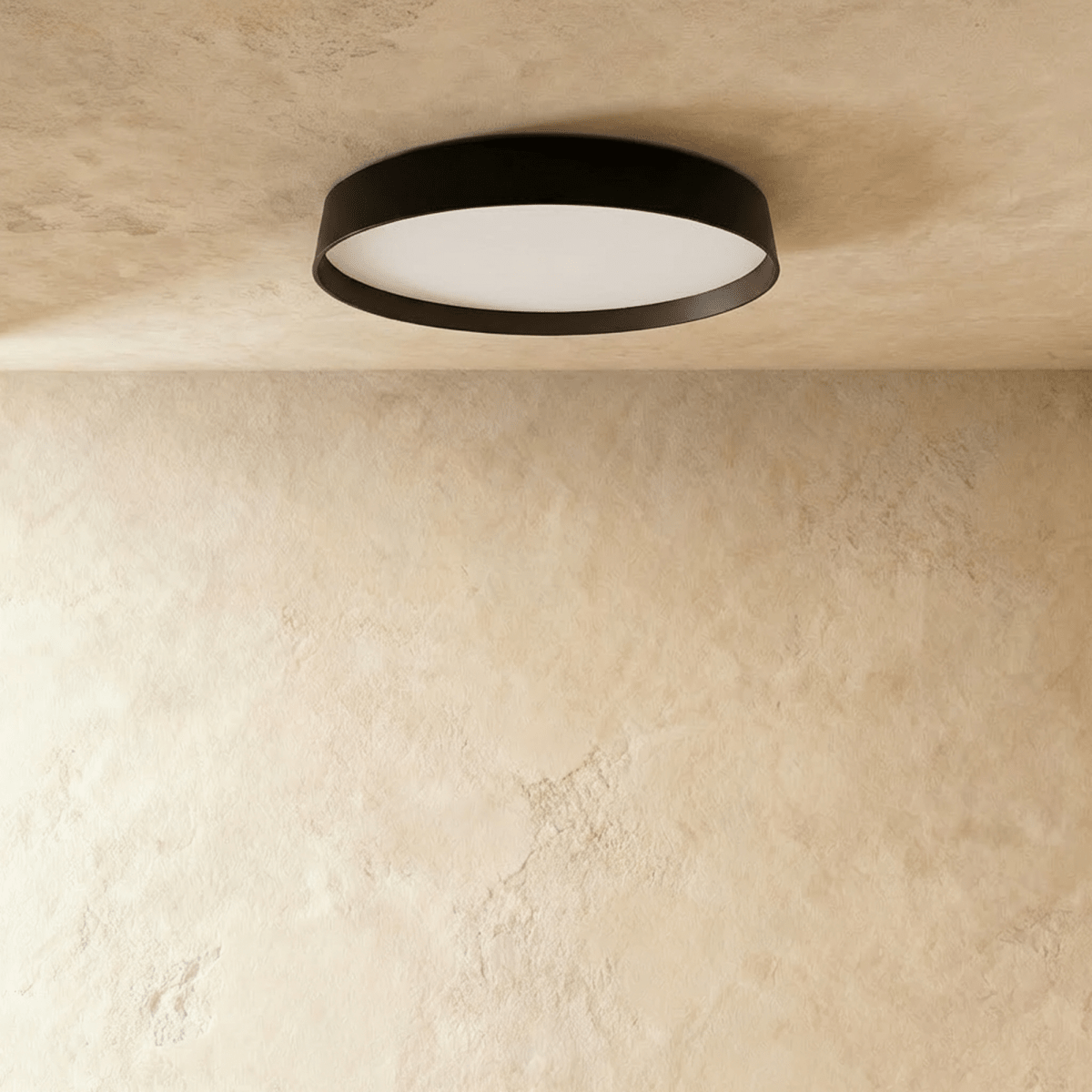 Clérachic slim black round ceiling light with its opal diffuser unlit, seen from below against a limewash plaster ceiling.