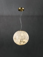 The Clérachic pendant against grey plaster, full drop shown from brass canopy through the looped cable.
