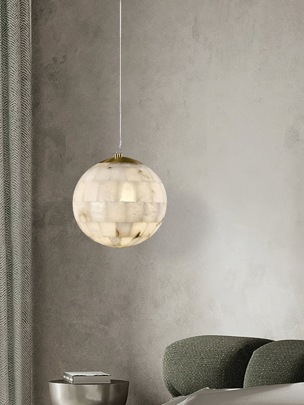 Clérachic pendant glowing on a plaster wall above a green sofa, ribbed curtains drawn to one side.