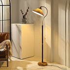 Beside a leather chair and a white plinth with a dried-stem vase, this Clérachic floor lamp's shade glows warm in a bright corner.