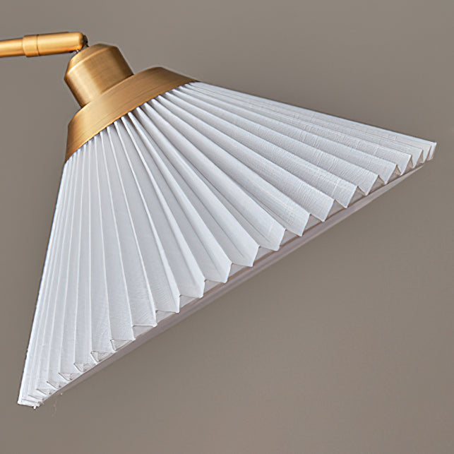 The white pleated shade of this Clérachic floor lamp, seen from the side, with its brass collar and the curved arm at the left.