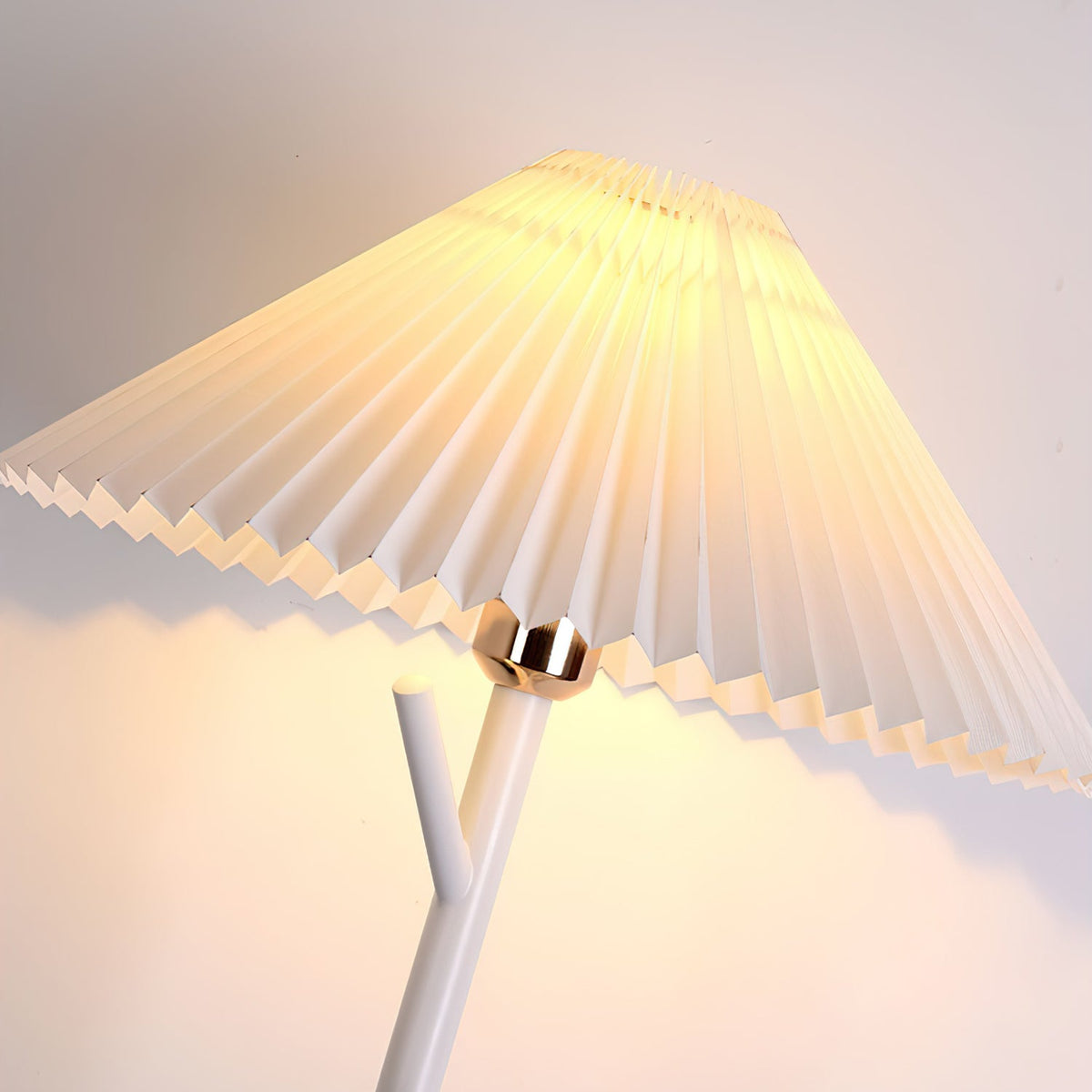 Close view of the pleated shade and brass-toned collar where a white branch arm meets this Clérachic floor lamp.
