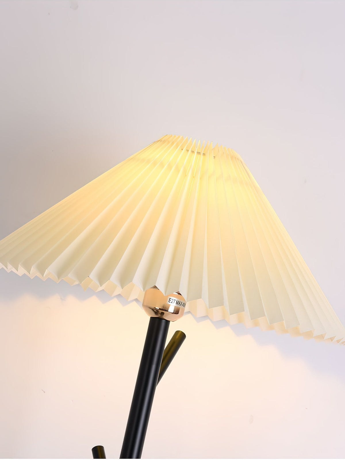 Close view of the pleated shade, brass-toned collar and black pole of this Clérachic floor lamp.
