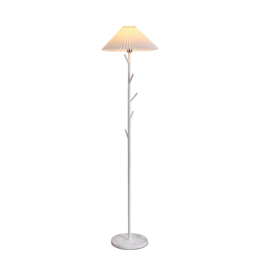 White Clérachic floor lamp, lit, with a pleated shade, three short branch hooks on the pole and a marble base on a white backdrop.