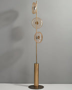 Full view of this Clérachic floor lamp, unlit, with three amber-tinted glass discs on a slim stem above a bronze cylinder base.