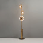 This Clérachic floor lamp switched on, with the lowest disc lit as a bright ring and the upper two glowing amber.