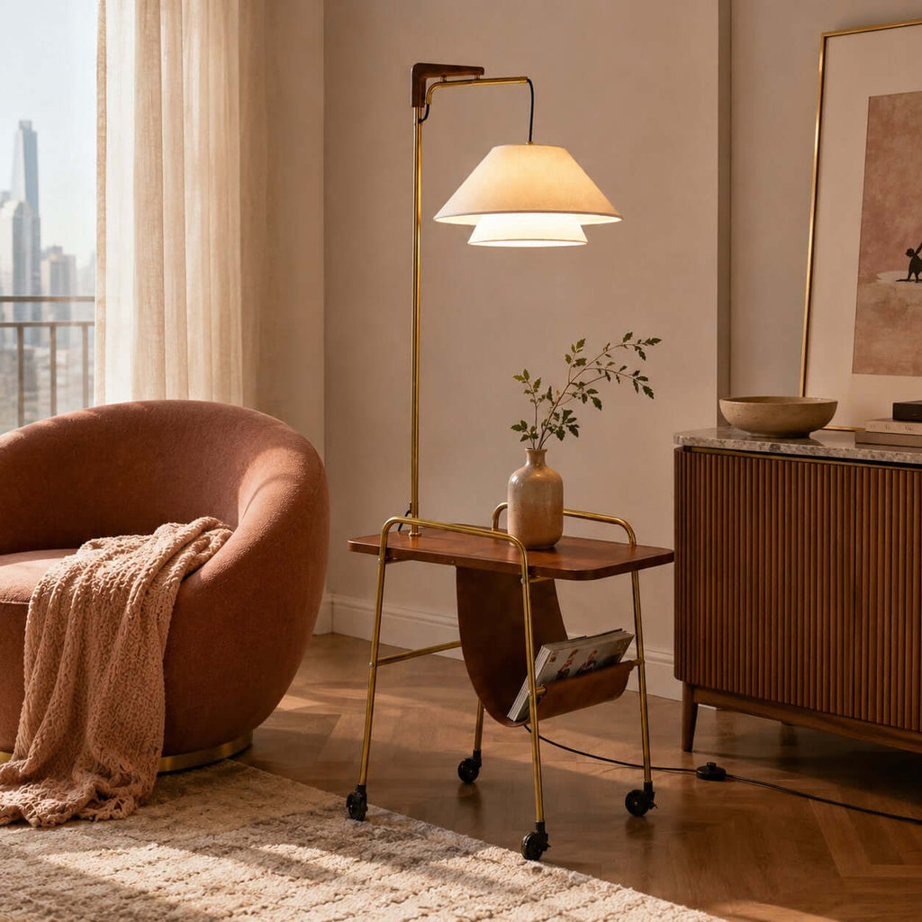 Brass and brown floor lamp with a leather magazine sling, from Clérachic, beside a rust-pink armchair and a wooden sideboard.
