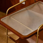 Close view of the ribbed glass tabletop in its wooden frame on this Clérachic floor lamp, with a brass rail at the edge.