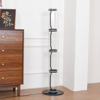 Unlit four-module Clérachic glass floor lamp in a panelled room next to a walnut chest, its black cord winding through clear glass cylinders.