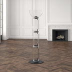 Unlit Clérachic glass floor lamp with a bowl top on a herringbone floor, in a white panelled room with a stone fireplace.