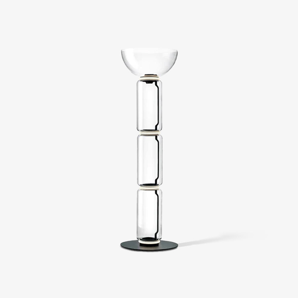 Clérachic glass floor lamp on white with three clear cylinders and a wide bowl shade, a soft shadow trailing on the floor.